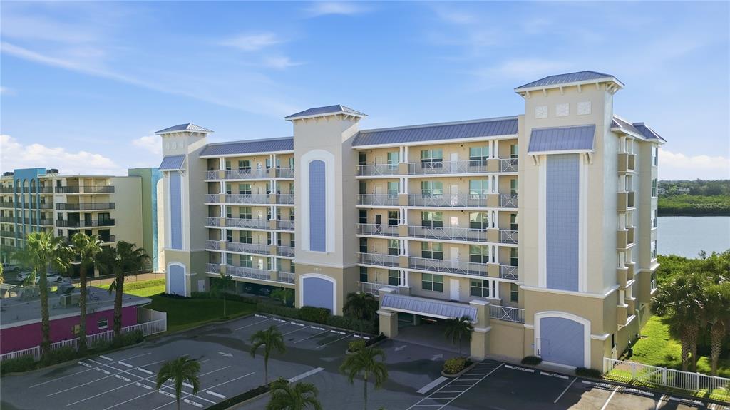 An exterior view of a multi-story apartment building with balconies and a parking lot — 19519 GULF BOULEVARD UNIT 403, INDIAN SHORES, FL