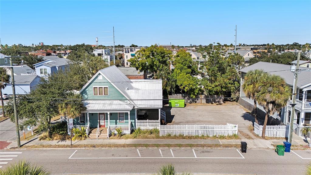 An aerial view shows a teal house with a metal roof and an adjacent vacant lot — 2002 E 4TH AVENUE, TAMPA, FL