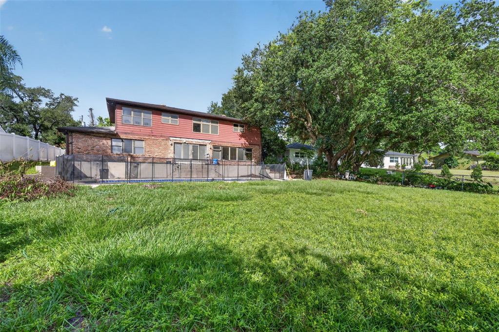 A two-story house with a brick and red siding exterior overlooks a backyard swimming pool — 3513 MARWOOD DRIVE, ORLANDO, FL