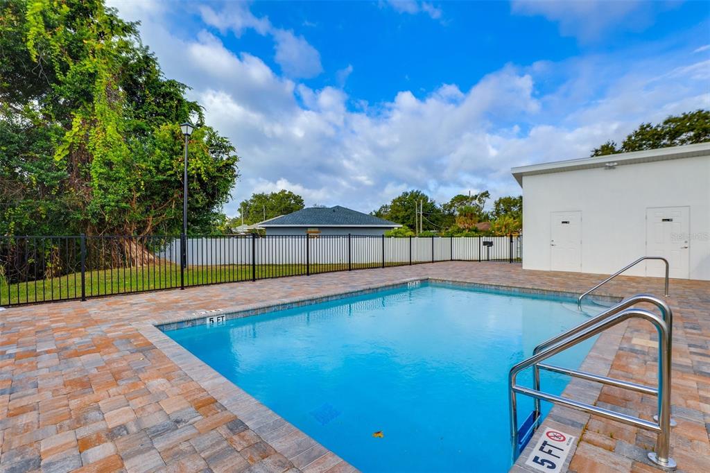 A rectangular swimming pool with a metal ladder sits on a paved patio area outdoors — 2441 6TH AVENUE DRIVE E, BRADENTON, FL