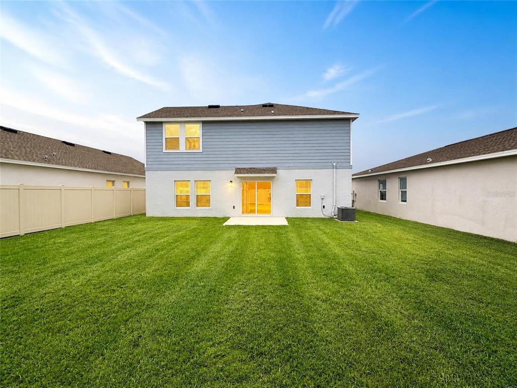 A two-story house with a blue-sided upper level and a white stucco lower level — 832 TIMBERLAND DRIVE, EAGLE LAKE, FL
