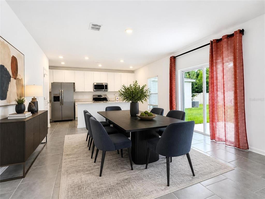 A dining area with a dark table and chairs sits adjacent to an open kitchen — 832 TIMBERLAND DRIVE, EAGLE LAKE, FL