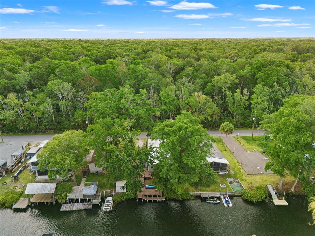 A light blue mobile home with a carport and a gravel driveway under a blue sky — 6380 RICHARD DRIVE, WEEKI WACHEE, FL