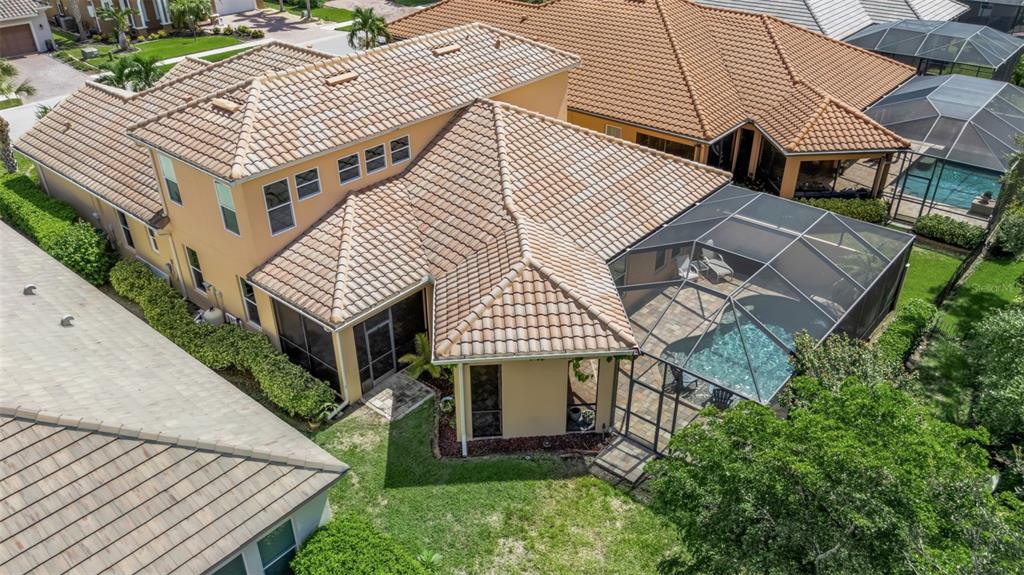 An aerial view of a two-story house with a tiled roof and a screened pool enclosure — 10310 EASTWOOD DRIVE, BRADENTON, FL