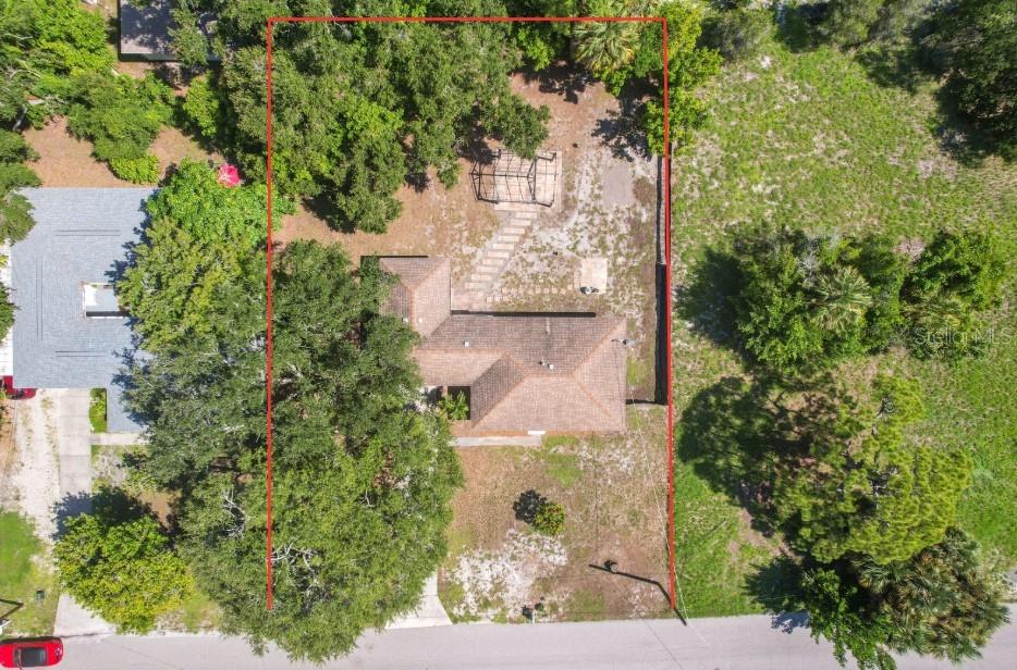 An aerial view shows a house with a brown roof on a wooded residential lot — 839 42ND STREET, SARASOTA, FL
