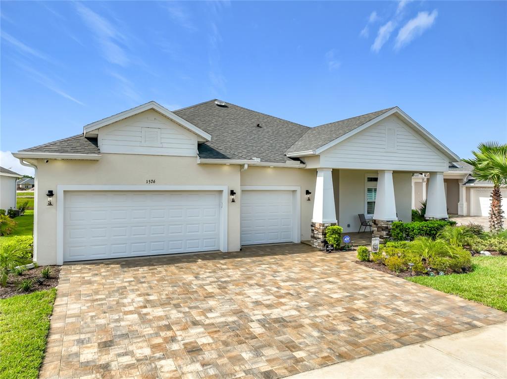 An aerial view of a single-story house with a paver driveway and a three-car garage — 1576 LAKE RESERVE DRIVE, DELAND, FL
