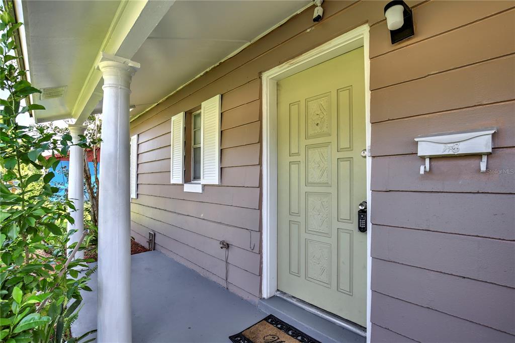 A front porch with a light green door, white columns, and a wall-mounted mailbox — 2319 CONTINENTAL BOULEVARD, ORLANDO, FL