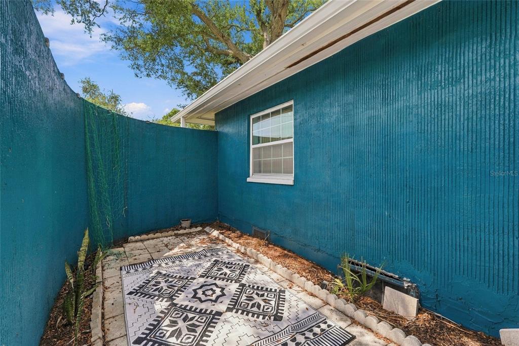 A living room features two blue armchairs, a fireplace, tile flooring, and a pass-through window — 4720 WELCH CAUSEWAY, ST PETERSBURG, FL