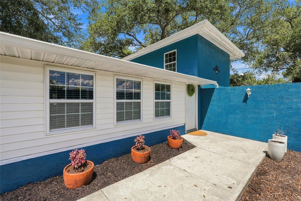 A living room features two blue sofas, a patterned area rug, and hardwood flooring — 4720 WELCH CAUSEWAY, ST PETERSBURG, FL
