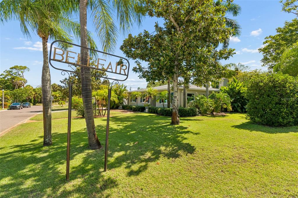 A single-story house with a light-colored exterior, a front lawn, and palm trees — 1743 EAGLES NEST DRIVE, BELLEAIR, FL