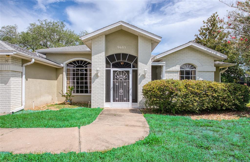 A single-story house with a white brick facade, arched windows, and a central entryway — 9685 SOUTHERN BELLE DRIVE, WEEKI WACHEE, FL