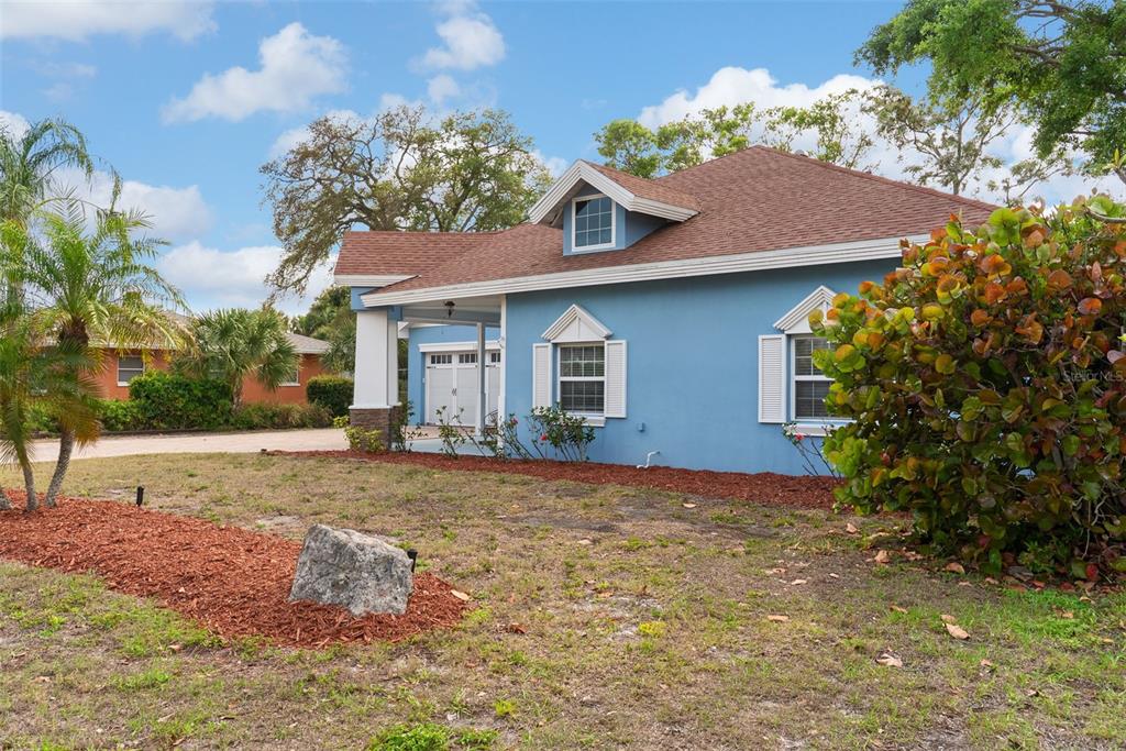 A blue single-story house with a brown roof, white trim, and a front-facing dormer window — 12080 143RD STREET, LARGO, FL