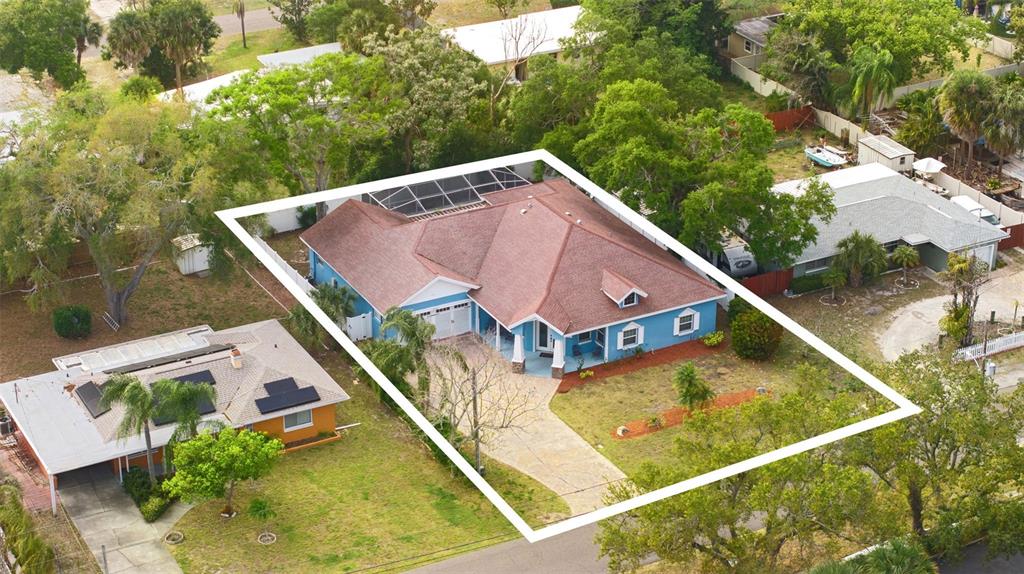 An aerial view of a blue single-story house with a brown roof and screened-in patio — 12080 143RD STREET, LARGO, FL