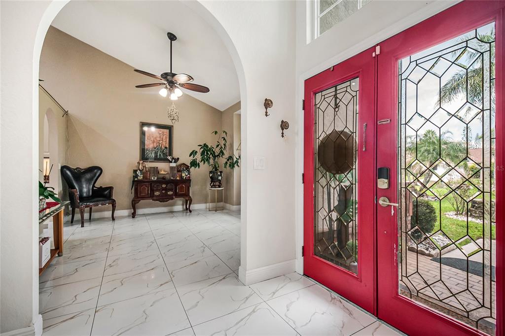 A bright room with white marble-look tile flooring, a vaulted ceiling, and a ceiling fan — 13522 HERON CAY COURT, ORLANDO, FL