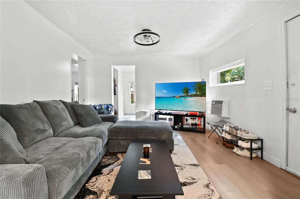 A living room with a grey sectional sofa, a coffee table, and a television — 725 NEW YORK ST, CLEARWATER, FL