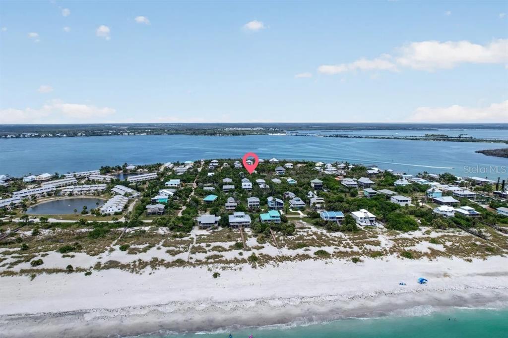 This aerial view shows a coastal neighborhood with houses situated near a sandy beach — 9602 DOUBLOON TRAIL, PLACIDA, FL