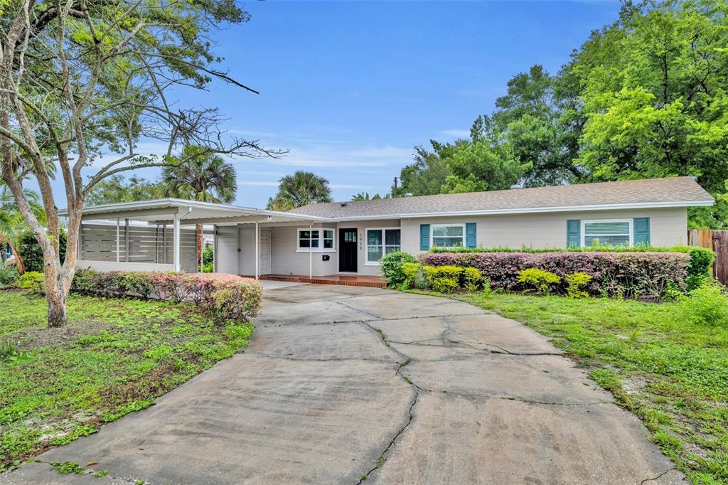 A single-story house with a concrete driveway, a carport, and a landscaped front yard — 1939 GUNN ROAD, WINTER PARK, FL