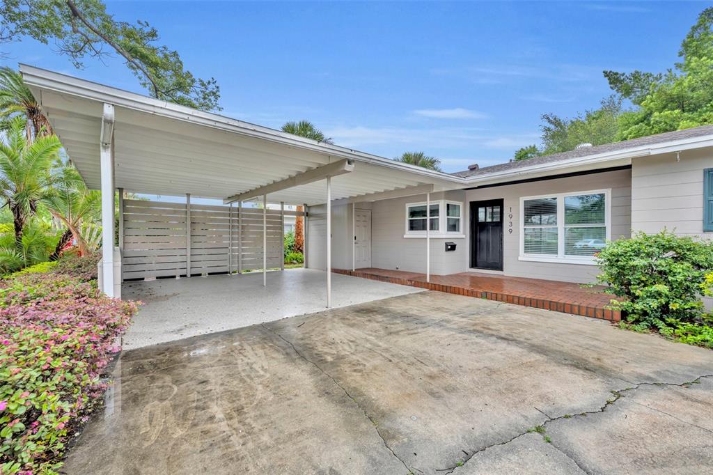 A single-story house exterior features a large carport, a brick porch, and a concrete driveway — 1939 GUNN ROAD, WINTER PARK, FL
