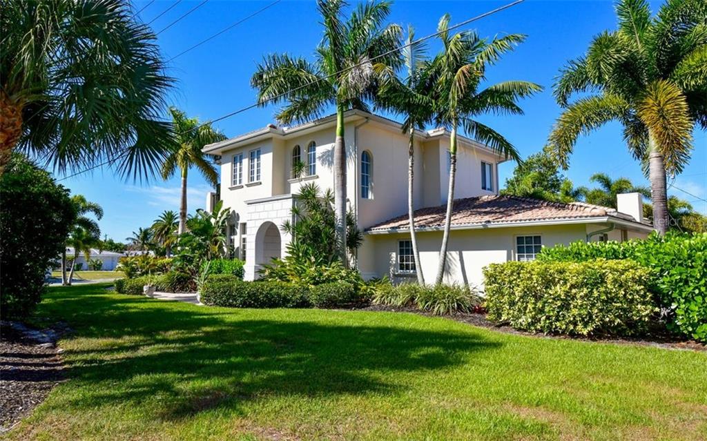 A two-story stucco house with a tile roof is surrounded by palm trees and landscaping — 1179 MORNINGSIDE PLACE, SARASOTA, FL