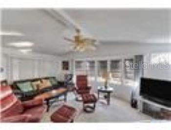 A living room features a ceiling fan, a sofa, a recliner, and a television — 6916 E BAYOU LANE, BRADENTON, FL