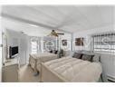 A bedroom features two beds, a ceiling fan, and a television mounted on the wall — 6916 E BAYOU LANE, BRADENTON, FL