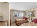 A bedroom features two twin beds with floral bedding and a window with blinds — 6916 E BAYOU LANE, BRADENTON, FL