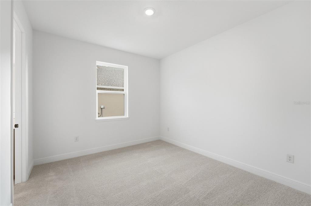 An empty bedroom features white walls, light-colored carpet, and a single window — 3500 LEMON BUTTON TERRACE, APOPKA, FL