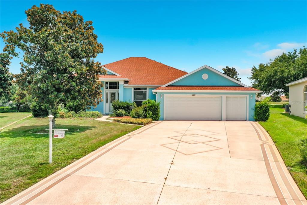 A single-story house with a light blue exterior, red roof, and a patterned concrete driveway — 4632 NOTTOWAY, LEESBURG, FL