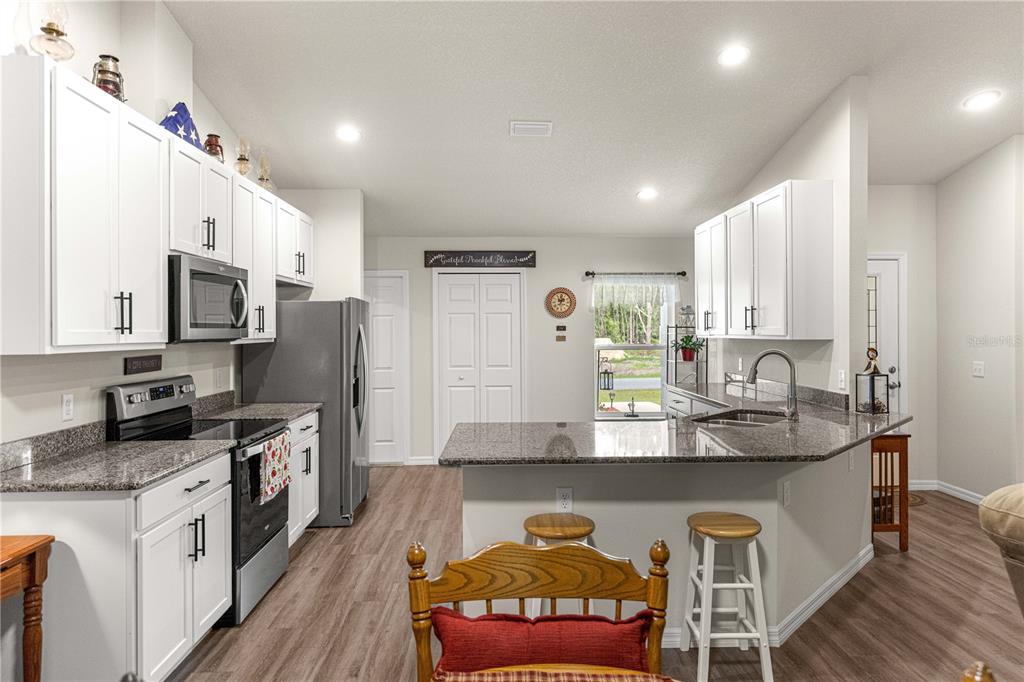 A single-story house with a white stucco exterior, a two-car garage, and a sunset sky — 10065 N LANGDON ROAD, CITRUS SPRINGS, FL