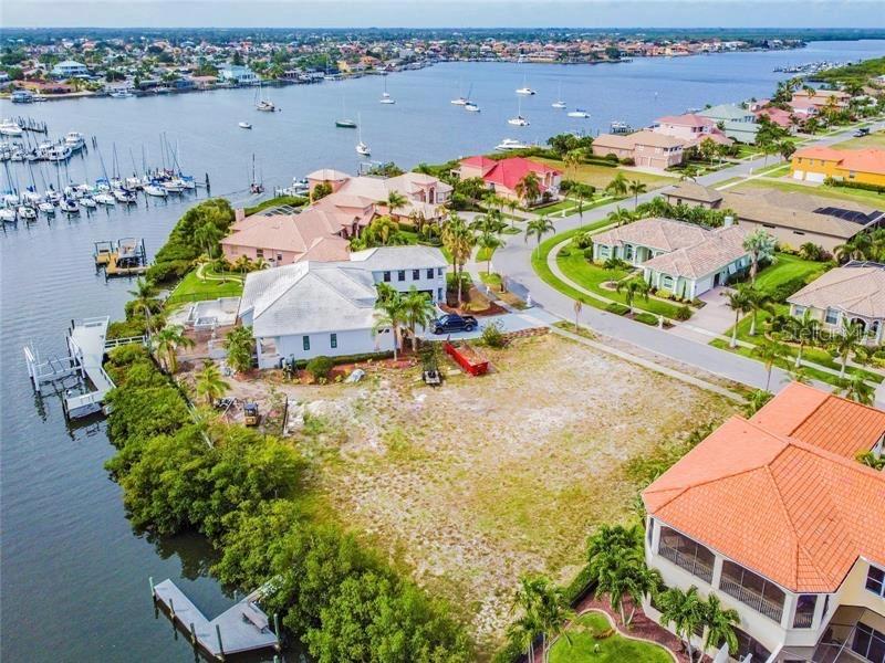 An aerial view shows a vacant waterfront lot situated between two large residential homes — 6451 RUBIA CIRCLE, APOLLO BEACH, FL