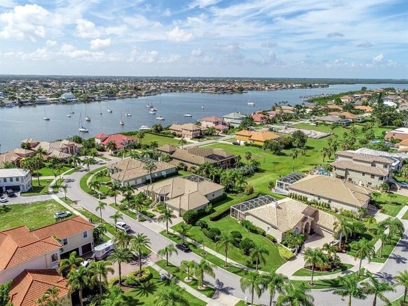An aerial view shows suburban houses with swimming pools near a bay filled with sailboats — 6451 RUBIA CIRCLE, APOLLO BEACH, FL