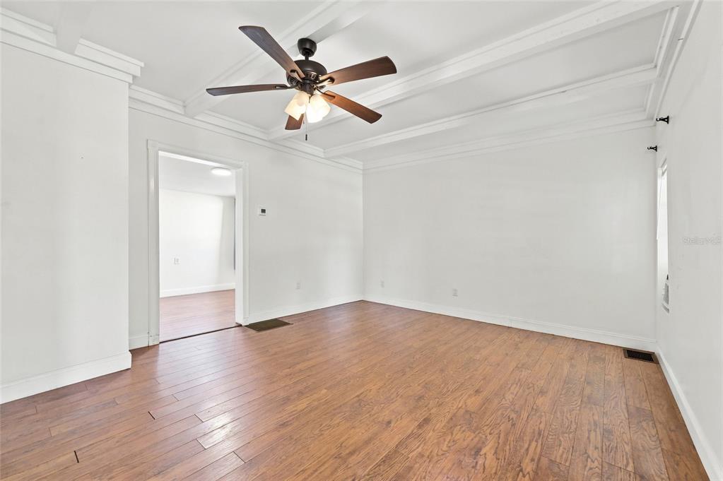 A living room with white walls, crown molding, a ceiling fan, and wood-look flooring — 4 E BAY STREET, DAVENPORT, FL