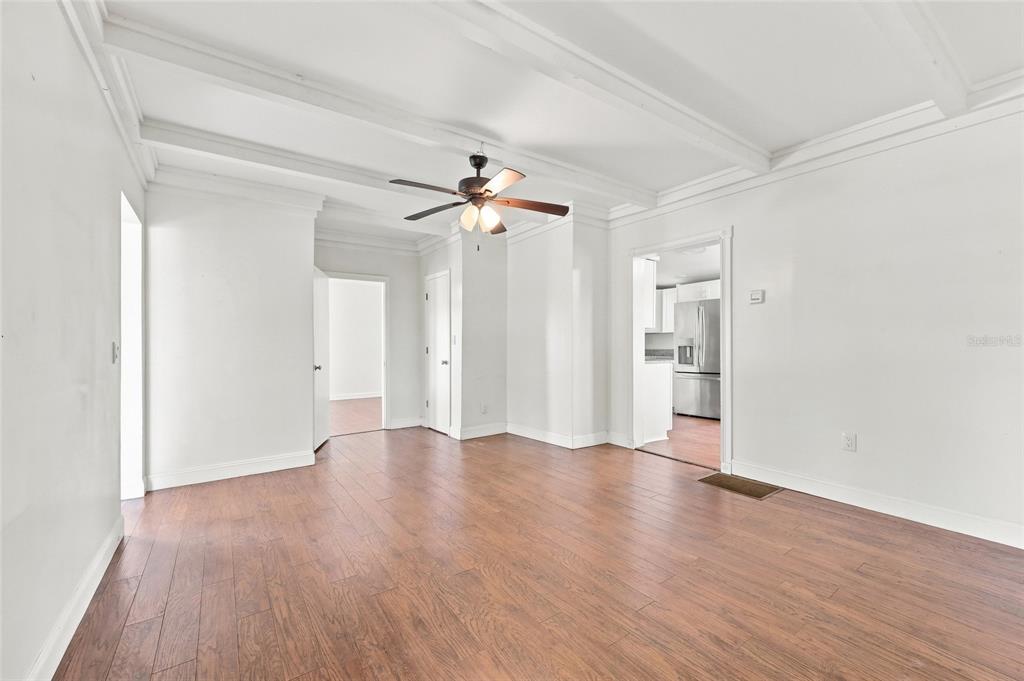 A living room with wood-look flooring, white walls, a coffered ceiling, and a ceiling fan — 4 E BAY STREET, DAVENPORT, FL
