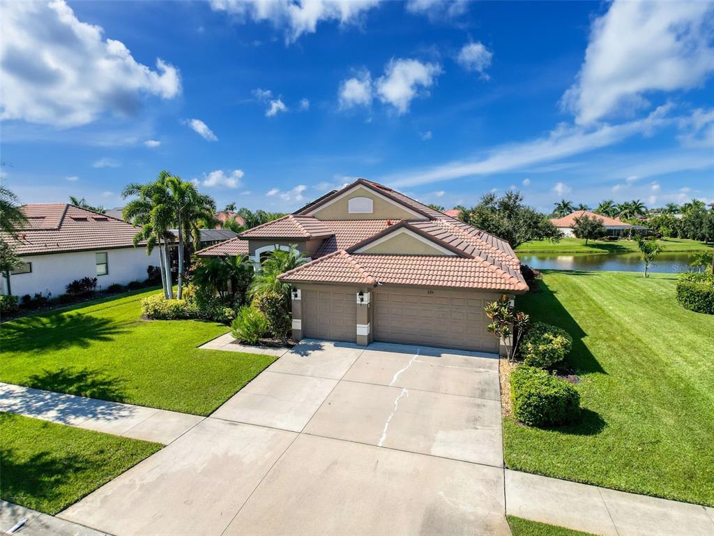 An elevated view of a single-story house with a tile roof and two-car garage — 335 COCKLE SHELL LOOP, APOLLO BEACH, FL