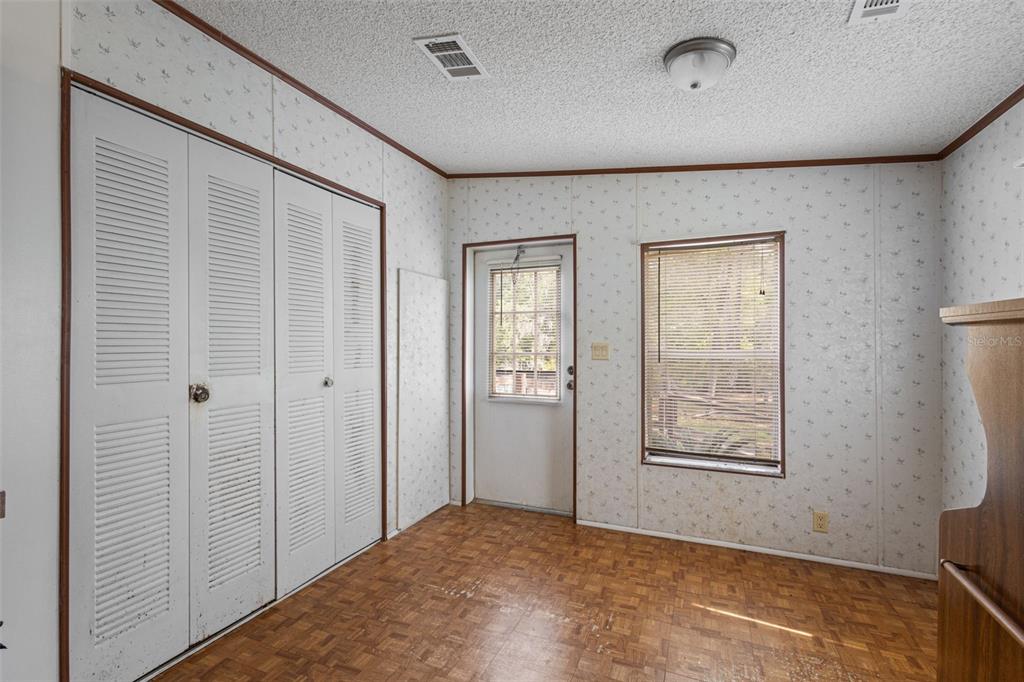 A carpeted living room opens to a kitchen and a sliding glass door to a porch — 704 SE 791ST STREET, OLD TOWN, FL