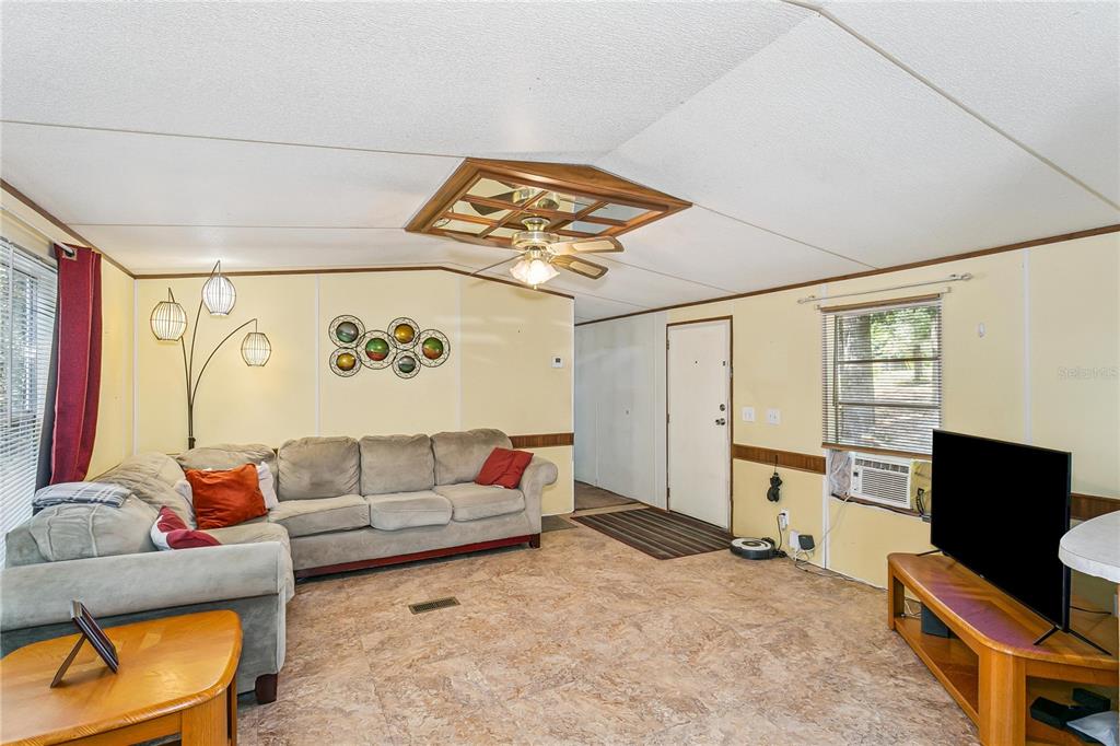 A living room features a sectional sofa, a ceiling fan, and light-colored walls — 2323 CAMORS ROAD, JAY, FL