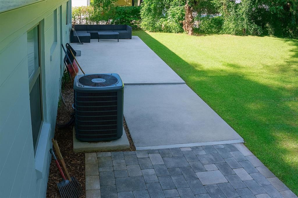 A backyard features a concrete patio, a paver walkway, and an air conditioning unit — 1019 SANTA BARBARA ROAD, ORLANDO, FL