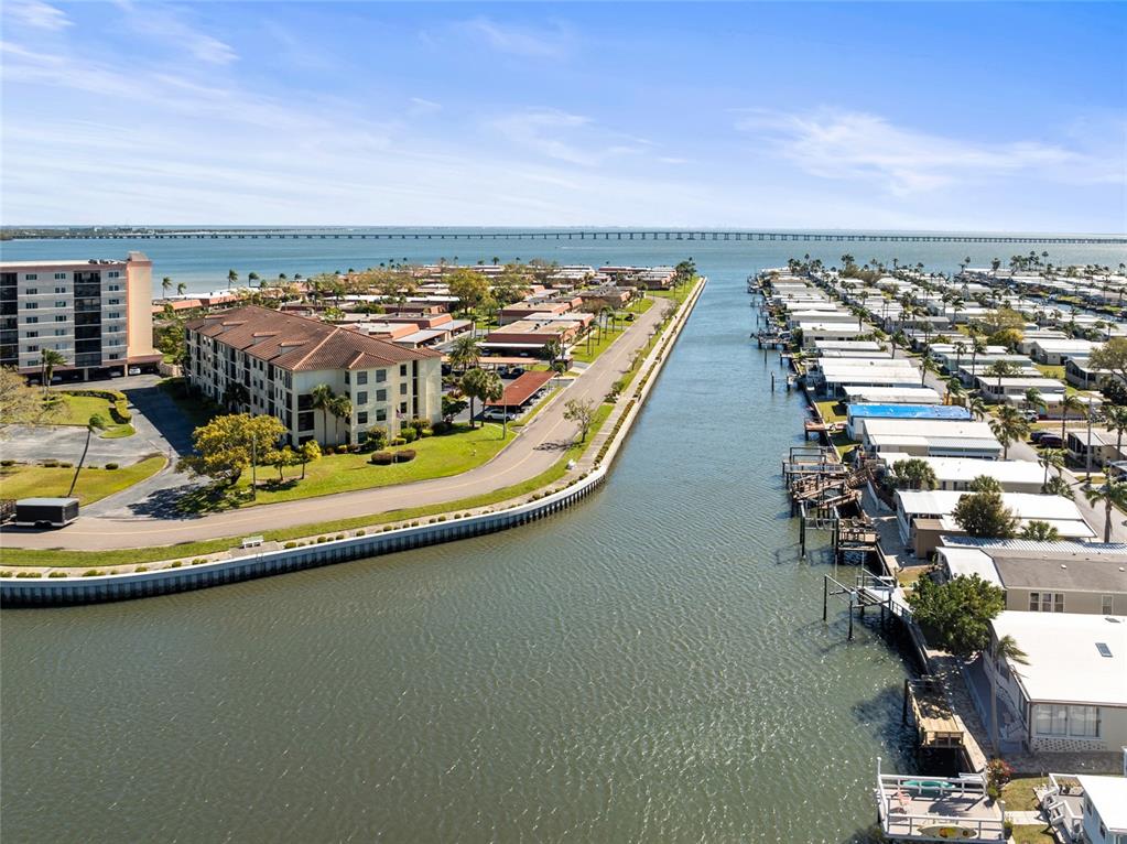 An aerial view shows a canal separating a residential complex from a mobile home park — 19029 US HIGHWAY 19 N UNIT 7-9, CLEARWATER, FL