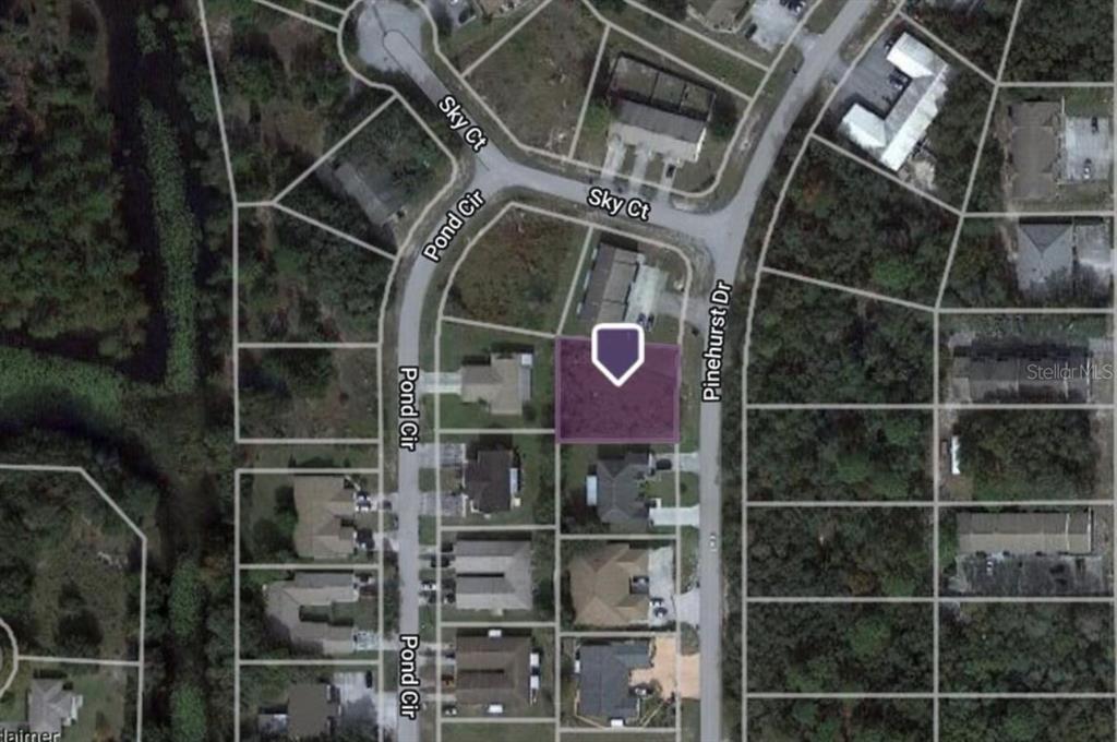 This is a satellite map view showing a residential lot highlighted in purple — 7997 PINEHURST DRIVE, SPRING HILL, FL