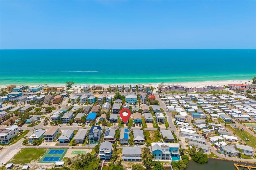 An aerial view shows a coastal neighborhood with houses near the beach and a canal — 2513 AVENUE B UNIT B, BRADENTON BEACH, FL