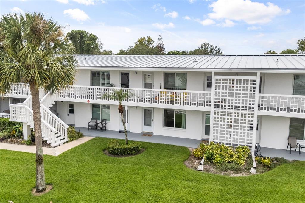 A two-story apartment building with white exterior walls, a metal roof, and a palm tree — 1140 S ORLANDO AVENUE UNIT G3, MAITLAND, FL