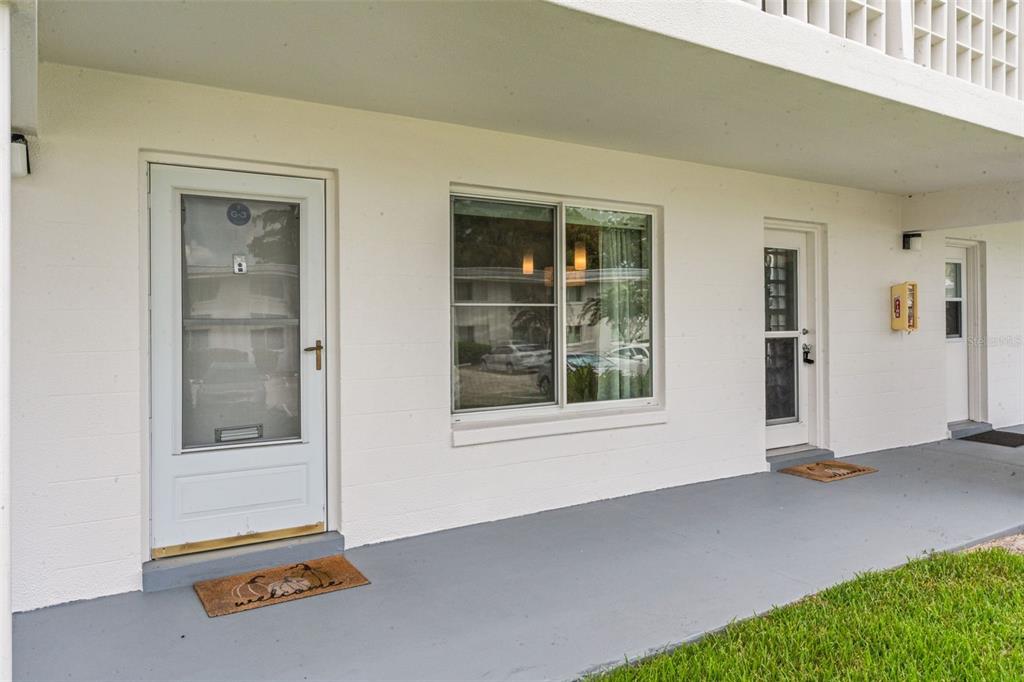 A white exterior building facade with two doors, a window, and a gray concrete walkway — 1140 S ORLANDO AVENUE UNIT G3, MAITLAND, FL