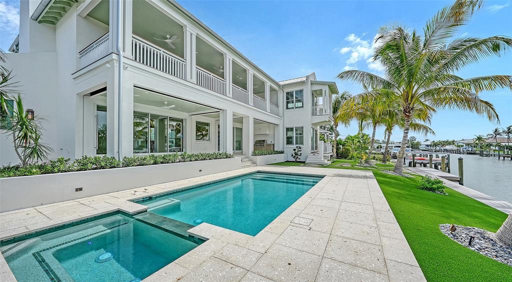 A two-story white house with a paved driveway, green shutters, and tropical landscaping — 711 OLD COMPASS ROAD, LONGBOAT KEY, FL
