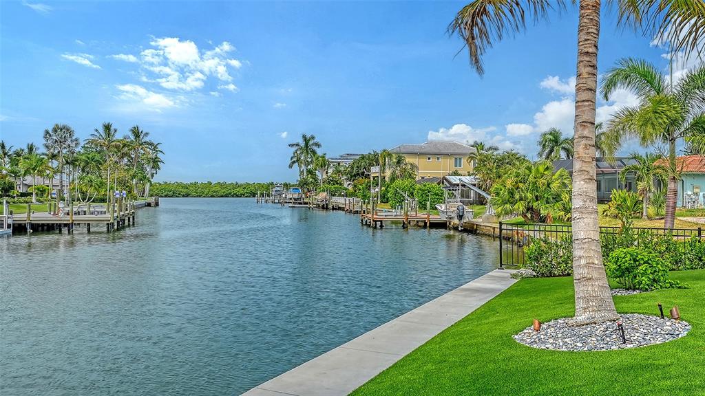 An aerial view of a light blue house with a metal roof and palm trees — 711 OLD COMPASS ROAD, LONGBOAT KEY, FL