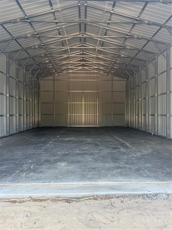 The interior of a large metal storage building features a concrete floor and metal walls — 7539 SW 129TH TERRACE ROAD, DUNNELLON, FL