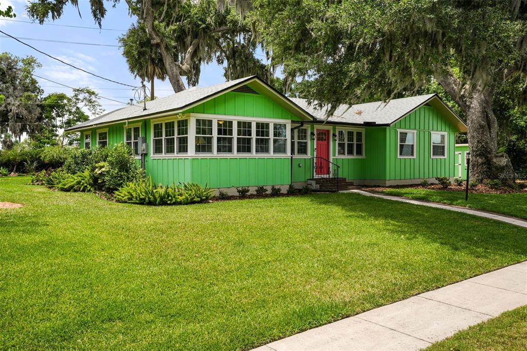 A bright green, single-story house with a red front door and a large front lawn — 1338 HEIM ROAD, MOUNT DORA, FL