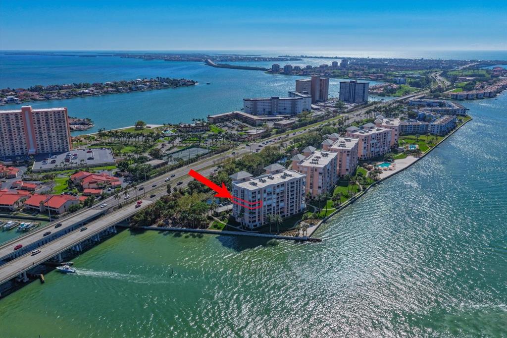 A covered balcony features a storage chest, two chairs with blue cushions, and a door — 4993 BACOPA LANE S UNIT 505, ST PETERSBURG, FL