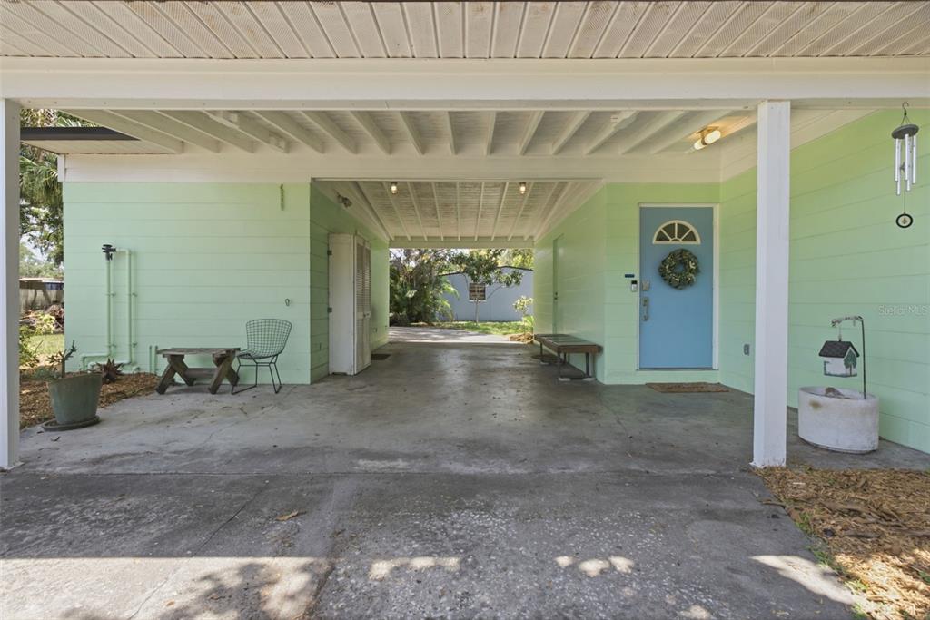 A light green house features a covered carport and a blue front door — 609 W RIVER DRIVE, TEMPLE TERRACE, FL
