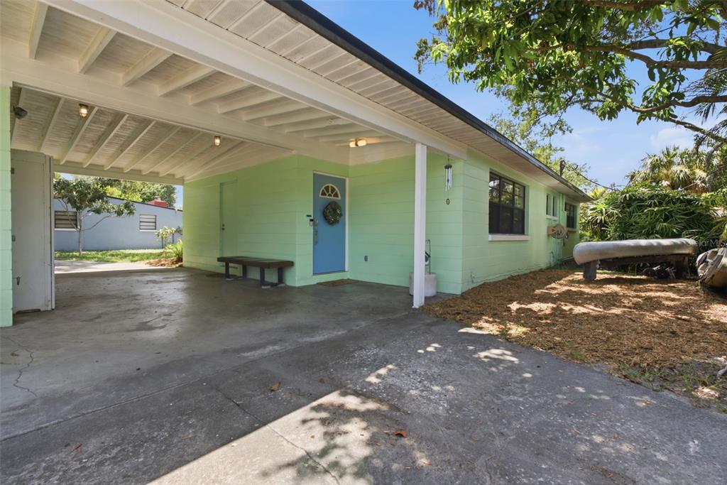 A light green house features a concrete carport, a blue front door, and a driveway — 609 W RIVER DRIVE, TEMPLE TERRACE, FL
