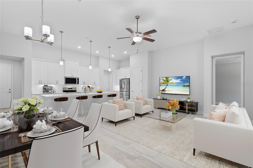 An open-concept living room and kitchen featuring white cabinetry, a dining area, and modern furniture — 335 MILLER ROAD, SANFORD, FL